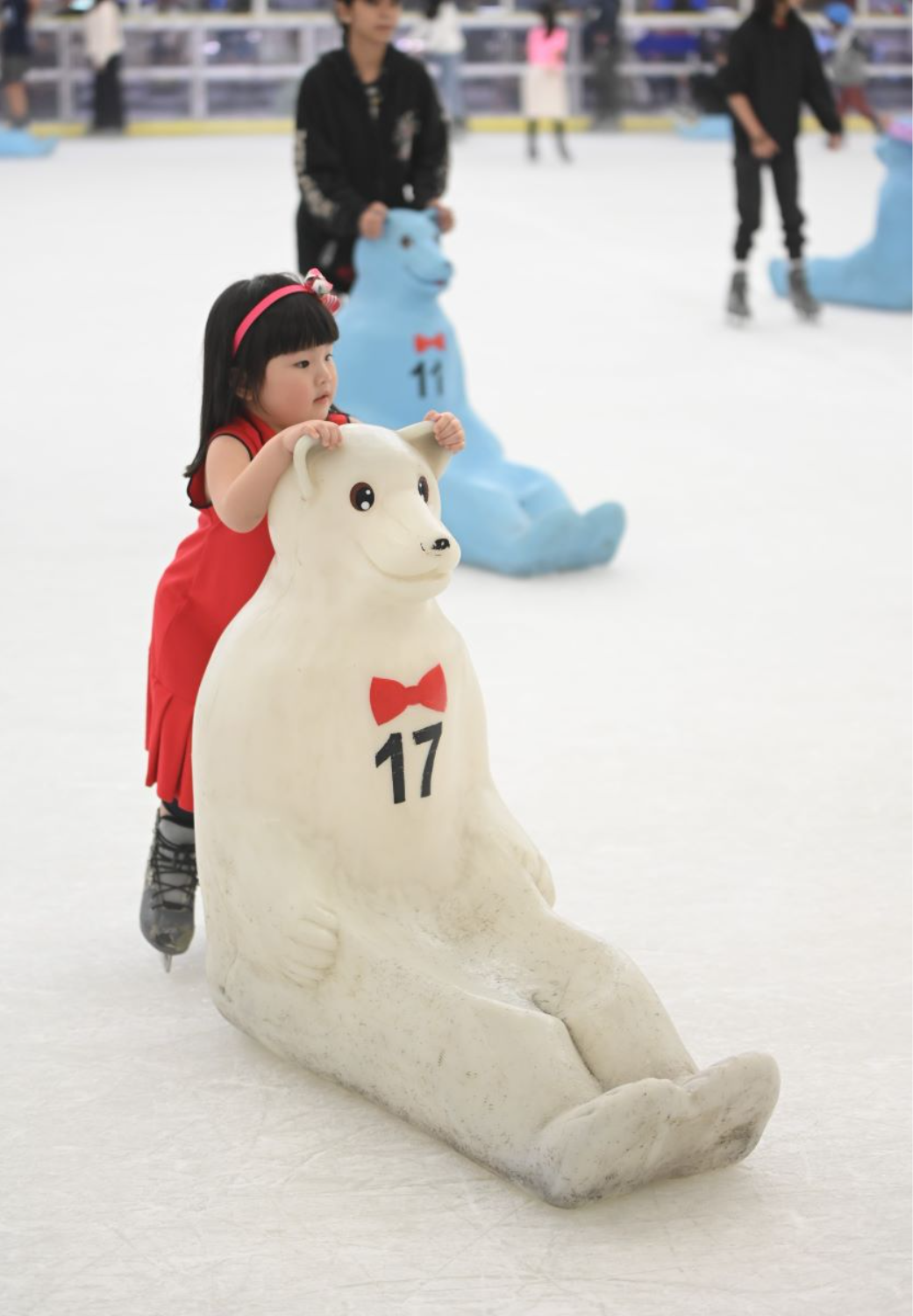 A_young_girl_learns_to_skate_with_the_assistance_of_a_polar_bear_skating_aid_at_SM_Skating_Megamal