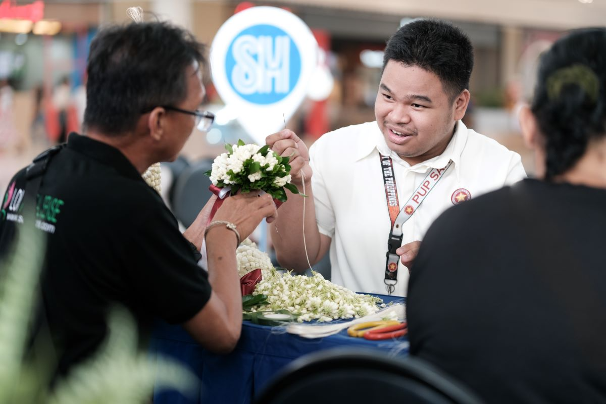 A_college_student_learns_to_thread_tradition_by_participating_in_a_Sampaguita_garland_making_activity